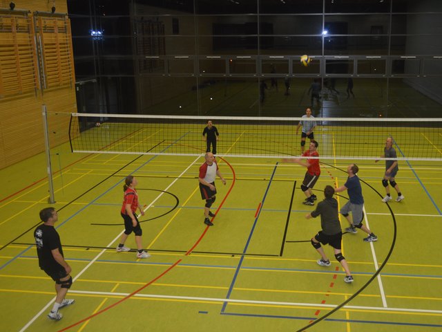 Männer spielen in einer Halle Volleyball